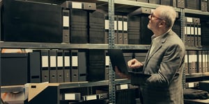 Mann prüft GoBD-konforme Archivierung in einem Archiv